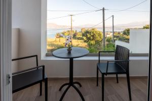 a table and two chairs in a room with a window at Eleftherias Suites - Near Beach Apartments in Marathi
