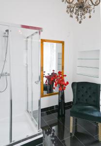 łazienka z krzesłem, lustrem i kwiatami w obiekcie Delightful Suite Hofburg w Wiedniu