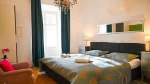 a bedroom with a large bed and a chair at Delightful Suite Hofburg in Vienna