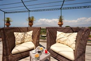 2 sillas de mimbre en un patio con mesa en Hotel dei Congressi, en Castellammare di Stabia