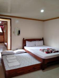 a bedroom with two beds and a mirror at D'MESA Seacretlodge and Restaurant in Taytay