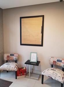 リオ・グランデにあるHimmel Blau Rentalsの椅子2脚とテーブル1台(壁に絵付)が備わる客室です。