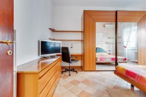a bedroom with a desk with a tv and a bed at Darsena & Navigli Cosy Flat in Milan