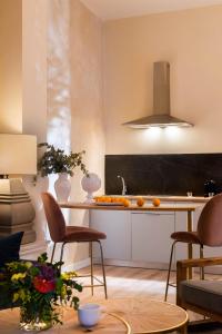 a kitchen with a counter with chairs and a table at Casa Sevilla 1855 Suites by Época in Seville