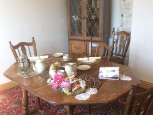 a wooden table with dolls and flowers on it at Laurel Lodge in Horncastle