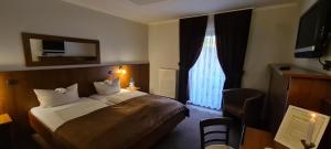 Cette chambre comprend un lit et une grande fenêtre. dans l'établissement Hotel zur Riede bei Bremen, à Delmenhorst
