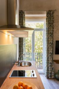 a kitchen counter with a sink and a window at Casa Sevilla 1855 Suites by Época in Seville
