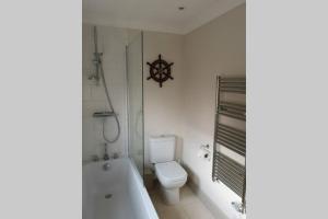 a bathroom with a toilet and a tub and a sink at Blakeney Norfolk Bramble Lodge ***Self Catering*** in Blakeney +34 photos