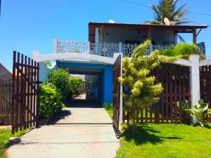 a house with a wooden gate and a walkway at Pousada Morada dos Pássaros in Peruíbe +5 photos