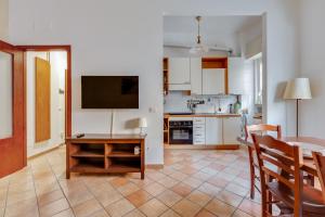 a kitchen and dining room with a table and a television at Darsena & Navigli Cosy Flat in Milan