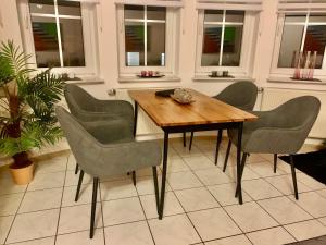 a table and chairs in a room with windows at Ferienwohnung Kaspers in Schalkenmehren