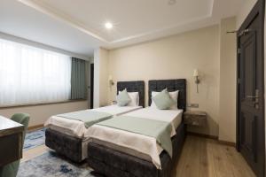 A bed or beds in a room at Florya Novi Hotel