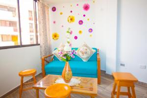 una sala de estar con un jarrón de flores en la pared en El Velero Apartamentos By DANP, en Santa Marta