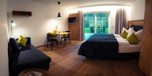 a hotel room with a bed and a table and a chair at Das Luegstein in Kiefersfelden