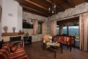 a living room with a stone wall at Sunset Traditional House in Ravdhoúkha