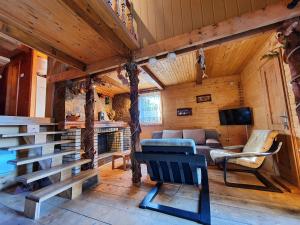 a living room with a couch and a fireplace in a cabin at VILA PAVLOVIC in Kopaonik
