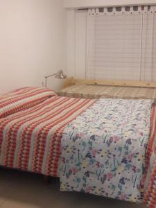 Un dormitorio con una cama con una manta. en Departamento 1 ambiente Excelente ubicación en Mar del Plata en Mar del Plata