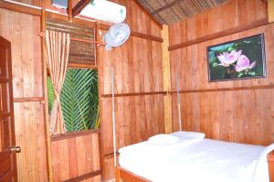 a small room with a bed and a window at Ben Tre Farm Stay in Ben Tre