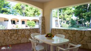 ヴィエステにあるVillaggio Camping Spiaggia Lungaの窓付きの客室で、白いテーブルと椅子が備わります。
