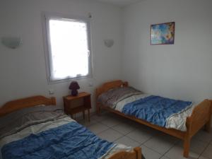 - 2 lits dans une chambre avec fenêtre dans l'établissement Orée de La Dune, à Biscarrosse-Plage