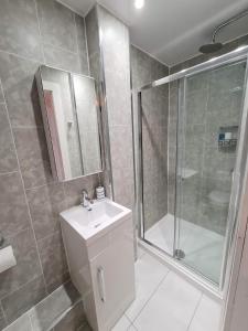 La salle de bains est pourvue d'un lavabo et d'une douche. dans l'établissement The Edinburgh Victorian - 3 Bedroom Apartment, à Édimbourg