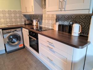 a kitchen with a counter top and a dishwasher at The Edinburgh Victorian - 3 Bedroom Apartment in Edinburgh