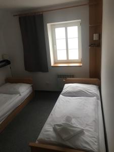 2 camas en una habitación pequeña con ventana en Knežicka chalupa en Vrchlabí