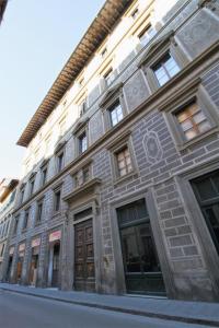 un gran edificio de piedra con ventanas y puertas en una calle en Corsini Tintori, en Florencia