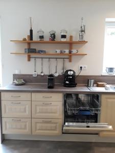 a kitchen with an open dishwasher in a sink at Maison et vélos à Godinne dans la Vallée de la Meuse in Godinne