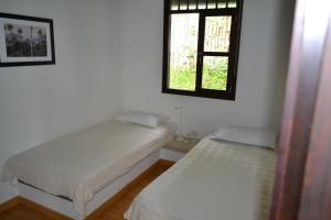 two twin beds in a room with a window at Casa de la Ciencia in Salento