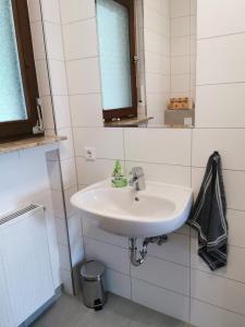 y baño con lavabo blanco y espejo. en Ferienhaus Nele en Hilders