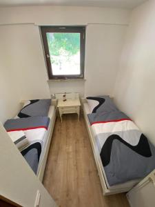 twee bedden in een kleine kamer met een raam bij Ferienhaus Nele in Hilders
