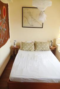 1 dormitorio con 1 cama blanca grande y 2 mesas en NEW- Rodney Bay two bedrooms BEST VIEW 6, en Gros Islet