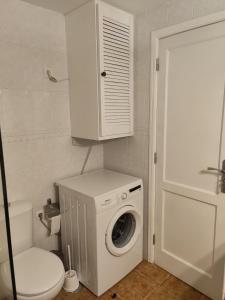 Un baño con lavadora y un inodoro. en Orion, en Puerto Naos
