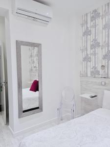 a white bed sitting in a room next to a mirror at Hostal Met Madrid in Madrid