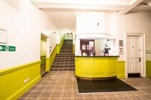 a hallway with yellow and green walls and stairs at Safestay Glasgow Charing Cross in Glasgow