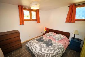 a bedroom with a bed and a dresser and windows at Le Balcon des Charmottes in Névache