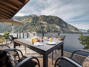 un tavolo su un balcone con vista sulle montagne di Platzhirsch Apart & Mayrhofen a Mayrhofen