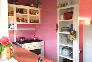 a kitchen with pink walls and a stove at Large Cottage Rodney Bay 2 bedrooms 2 bathrooms in Gros Islet