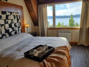 a room with a bed with a tray with cups on it at GreJa Lodge, Limay, Patagonia in Dina Huapi