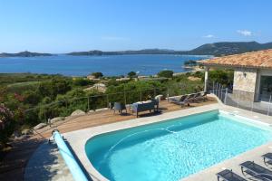 een zwembad met uitzicht op het water bij Magnifique villa vue mer et piscine chauffée à 250m de la mer in Sainte-Lucie de Porto-Vecchio