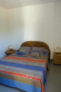 een slaapkamer met een groot bed met blauwe kussens bij Magnifique villa vue mer et piscine chauffée à 250m de la mer in Sainte-Lucie de Porto-Vecchio