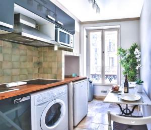 eine Küche mit einer Waschmaschine und einem Tisch in der Unterkunft 834 - Spacious flat in Paris Olympic Games 2024 in Paris