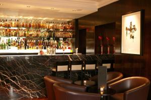 un bar con sillas marrones y una barra con alcohol en The Glenmoriston Townhouse Hotel en Inverness