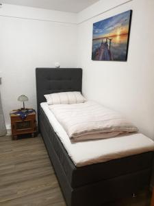 a bed in a room with a picture on the wall at Hotel Restaurant Bauernstube in Eschenburg +13 photos
