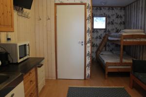 a kitchen with a door leading to a room with a bunk bed at Motel Willis West in Ruka