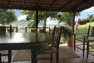una mesa de cristal y sillas en una terraza con vistas en Creole house 2 bedrooms with garden Best View Rodney Bay 21, en Gros Islet