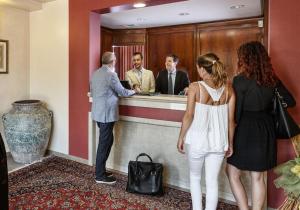 un grupo de personas esperando en un mostrador de hotel en Hotel Daniel en Basiano