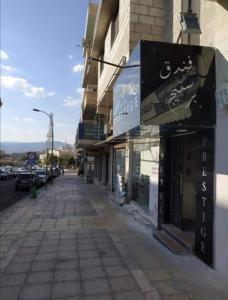 an empty street in a city with a building at Hotel Prestige in Aqaba