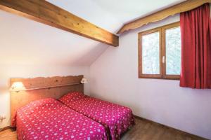 een kleine slaapkamer met een bed en een raam bij Residence La Crete du Berger - maeva Home in La Joue du Loup